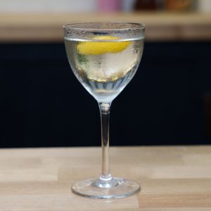 a picture of a vodka martini in a table with lemon twist as garnish