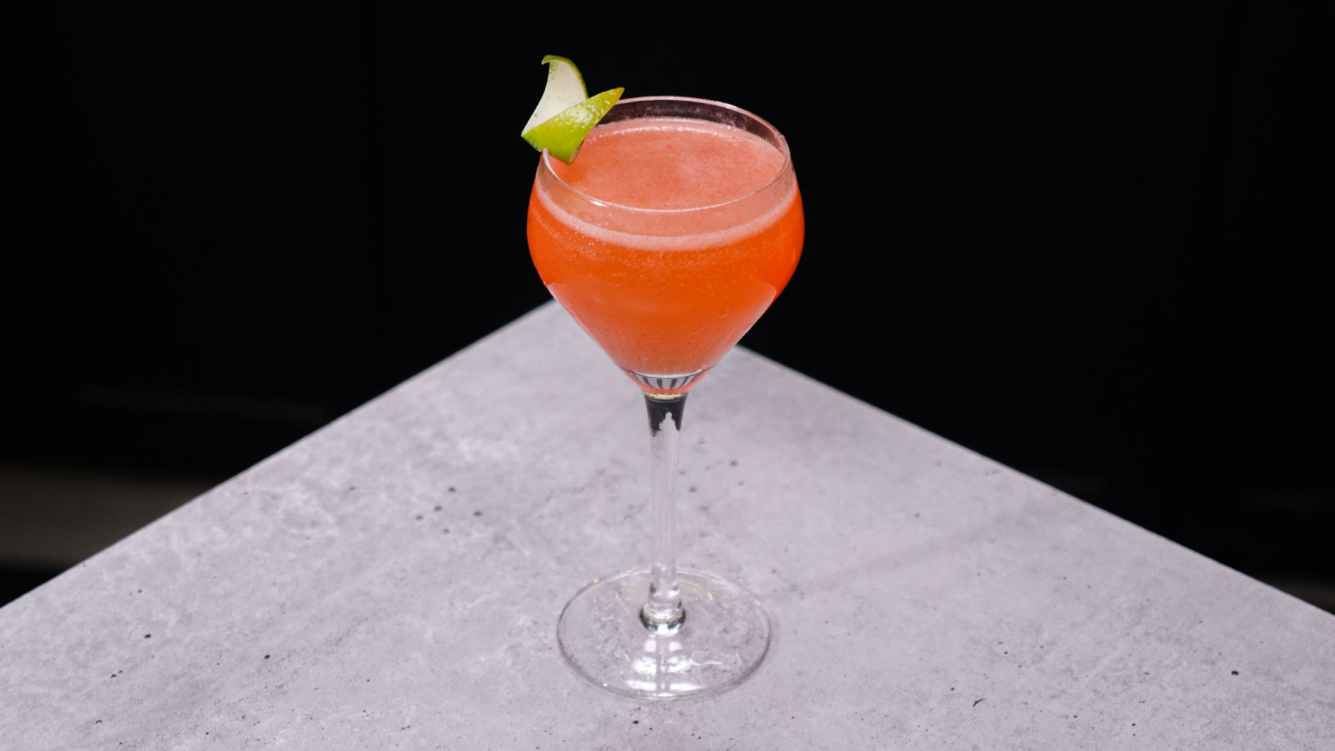 Strawberry Daiquiri drink with a lime twist as garnish